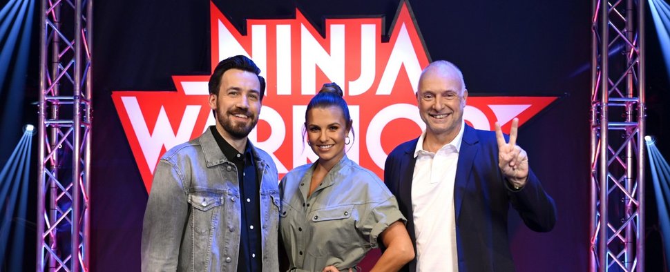 Jan Köppen (l.), Laura Wontorra und Frank Buschmann moderieren „Ninja Warrior Germany“ – Bild: TVNOW / Markus Hertrich