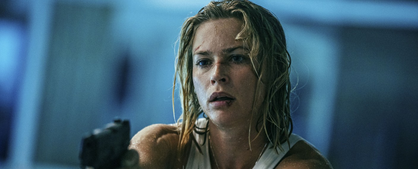 „Exterritorial“: Schlagkräftiger Trailer zum deutschen Netflix-Actionthriller enthüllt – Ex-Elitesoldatin sucht in US-Konsulat nach verschwundenem Sohn – Bild: Netflix/​Sasha Ostrov