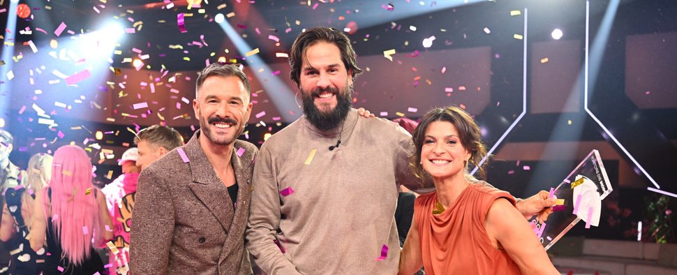„Promi Big Brother“: Gewinner Maurice Dziwak (M.) neben den Moderatoren Jochen Schropp (l.) und Marlene Lufen (r.) – Bild: Joyn/Willi Weber
