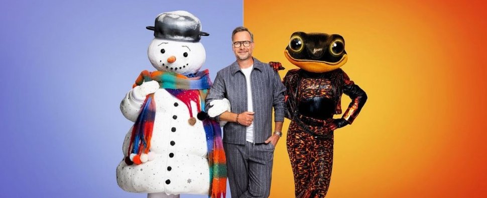 Staffel 11 von „The Masked Singer“ soll von Gegensätzen geprägt sein: Moderator Matthias Opdenhövel umgeben von Schneemann und Feuersalamander – Bild: Joyn / Nadine Rupp