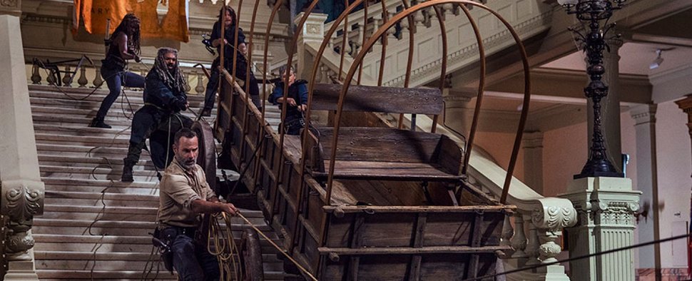 Rick (Andrew Lincoln), Ezekiel (Khary Payton), Michonne (Danai Gurira), Daryl (Norman Reedus) und Carol (Melissa McBride) befördern vorsichtig eine antike Kutsche die Stufen des Museums hinab – Bild: AMC