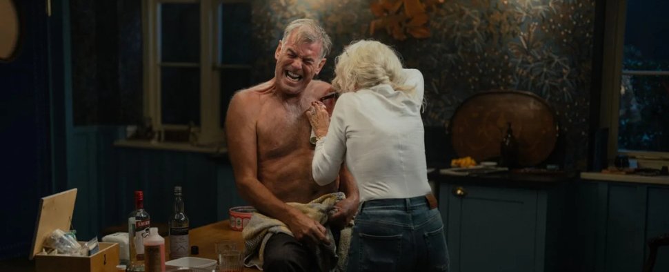 Wo gehobelt wird, da …: Conrad Harrigan (Pierce Brosnan) lässt sich von seiner Gattin Maeve (Helen Mirren) verarzten. – Bild: Paramount+/Luke Varley
