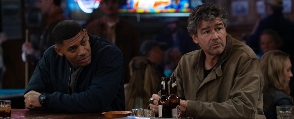 Zwei Laternen tanken Super: John Stewart (Aaron Pierre, l.) und Hal Jordan (Kyle Chandler) ermitteln in den Bars der Provinz. – Bild: HBO
